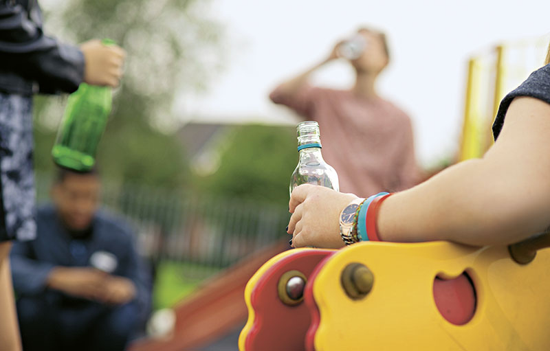 Alkohol trinkende Jugendliche auf Spielplatz