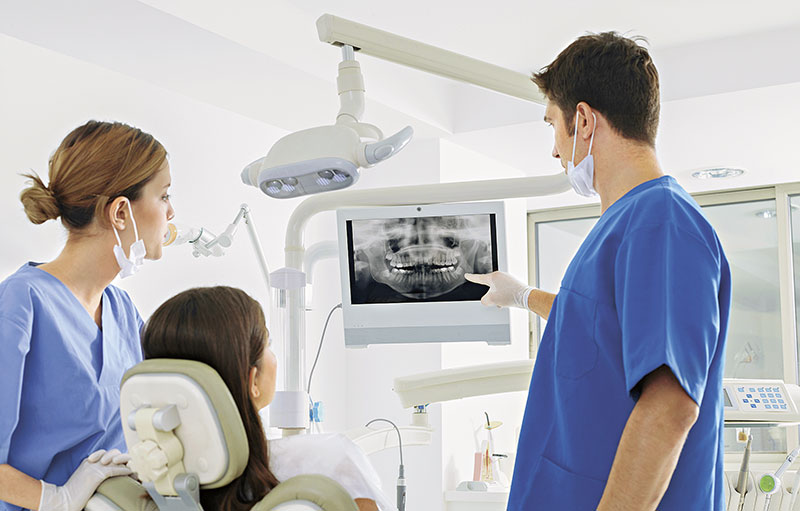 Zahnarzt erklärt Patientin Röntgenbild