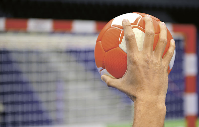Foto Hand mit Handball beim Wurf aufs Tor