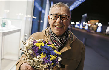 Foto älterer Mann mit buntem Blumenstrauß