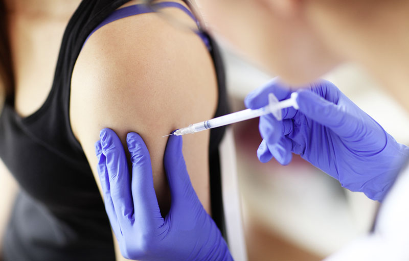 Frau erhält Impfung in den Oberarm