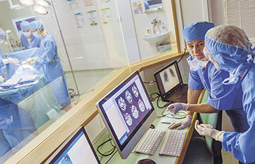 Laufende Operation mit medizinischem Personal im Vordergrund bei der Auswertung von digitalen Bildern