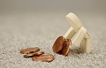 Foto Kleines Holzmännchen auf Teppich, das Ein-Cent-Münzen anhebt, um sie auf einen kleinen Haufen aus selbigen zu legen