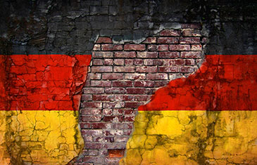 Mit Deutschlandflagge bemalte Wand, von der die Farbe bröckelt