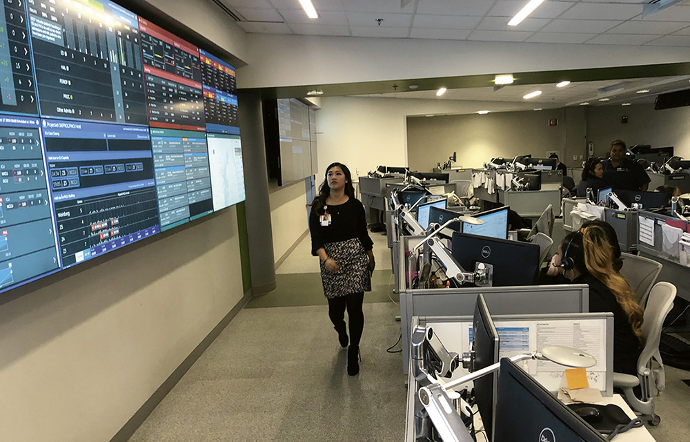 Foto, auf dem Mitarbeiterin Anna Ye an den riesigen Monitoren bei Johns Hopkins vorbeigeht