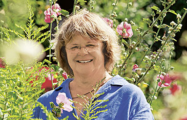 Foto der Soziotherapeutin Hede Schröer im, gemeinsam mit Patienten bewirtschafteten Garten