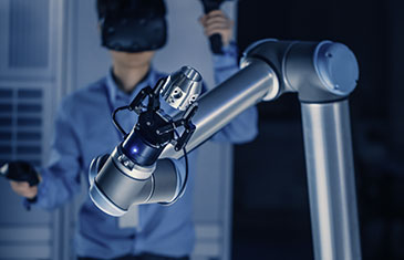 Foto eines Roboterarms, der von Mann via VR-Brille gesteuert wird