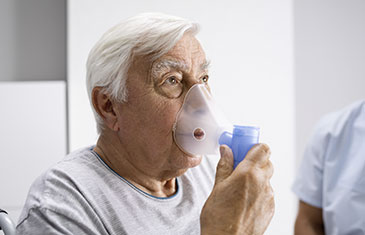 Foto eines alten Mannes beim Inhalieren