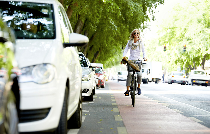 Foto einer jungen blonden Frau, die auf einem Fahrradweg fährt