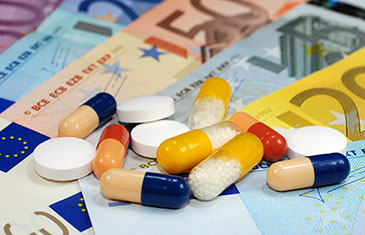 Foto von Tabletten und Kapseln, die auf Euro-Geldscheinen liegen 