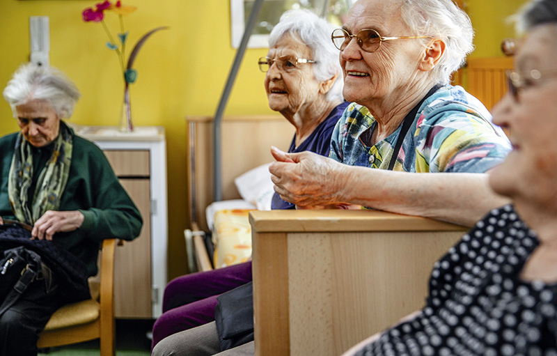 Foto von alten Frauen, die in einem Pflegeheim aufmerksam lauschend dasitzen