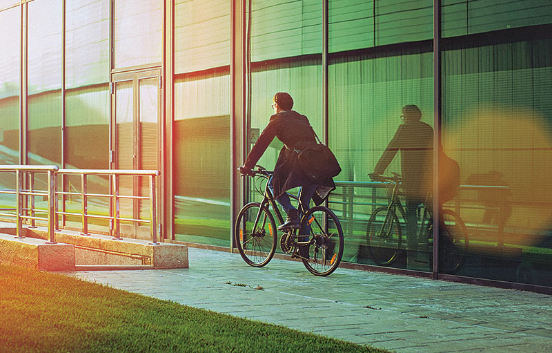 Foto eines Businessmannes mit dem Fahrrad auf dem Weg zur Arbeit