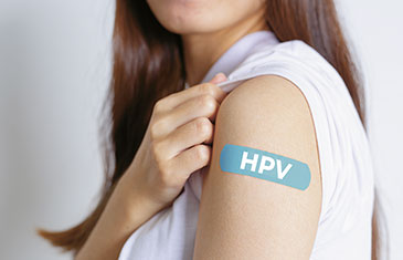 Foto einer Frau mit einem Impfpflaster auf dem linken Oberarm, darauf steht: 